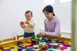 © leungchopan - Parent and child learning toy play indoors