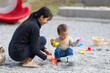 © leungchopan - Mother and baby enjoying pebble stone play outdoors