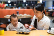 © leungchopan - Parent giving baby food in restaurant setting