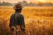 © Alex Photography - A farmer stands amidst a vast, golden wheat field at sunset, reflecting the serene beauty of rural life and agriculture.