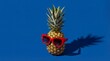© Yauhen - Ripe pineapple with red sunglasses on blue background. A playful summer kidult concept with vibrant colors and hard shadows. Perfect for vacation ads or party flyers.