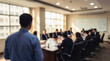 © Rahman - Blurred image of a businessman giving a presentation in a meeting room with colleagues