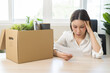 © KMPZZZ - Unemployment, quitting job, desperate asian young business woman holding a resignation letter, resigning from company packing belongings, stuff in box, layoff or leaving, changing work employment.