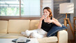 © Stella 16 - woman wears black tank shirt hold drink clear fresh pure still water from transparent glass sit on yellow couch stay at home flat rest relax spend free spare time in living room indoor