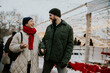 © BGStock72 - Couple enjoys winter time together in a festive outdoor market with lights in background