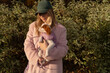 © Asya Molochkova/Stocksy - Owner in Pink Coat Holding Jacketed Cavalier Puppy