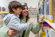 © unai - Mother and son choosing books in library