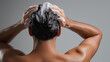 © Curioso.Photography - Back view of man washing hair with shampoo foam, highlighting daily hygiene and scalp care routine.