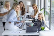 © ivanko80 - Group of women working together in an office during a morning meeting discussing ideas and sharing drinks