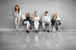 © ivanko80 - People sit in a line holding papers while waiting in an office during a job interview session