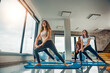 © ivanko80 - Group of women practicing yoga in a bright studio during daytime near a large window with a view