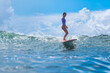 © truphotovideo - Young Woman Demonstrating Surf Technique On Gentle Swell, Confident Posture And Instructional Vibe With Bright