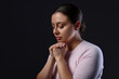 © New Africa - Woman praying on black background, space for text