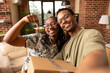 © DC Studio - Joyful black couple smiling while holding house keys and cardboard box, excited to move into newly purchased residential property. Black man takes selfie with wife, celebrating fresh start together.