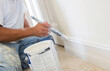 © jodi - Painter Applying Fresh Paint to Baseboard Trim During Interior Home RenovationClose-up of a painter brushing fresh paint onto a construction interior painter portrait