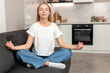 © brizmaker - Mindfulness practice from a woman sitting on a couch in her home
