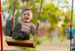 © geargodz - cheerful child girl playing on swing at playground