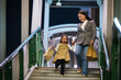 © geargodz - happy mother and child girl with shopping bag enjoying and walking down footbridge stairs in bangkok city at night