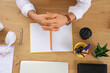 © Pixel-Shot - Young businessman with stationery, headphones and notebook at table in office, top view