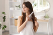 © Pixel-Shot - Beautiful young happy woman combing her hair in bathroom at home