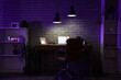 © Pixel-Shot - Interior of dark programmer's office with workplace, shelf units and glowing lamps at night