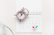 © Pixel-Shot - Calendar with alarm clock and pins on grunge white background. Planning concept