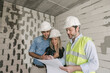 © Westend61 - Architect talking about architectural plan with future owners on construction site