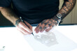 © Westend61 - Tattoo artist designing motif on light table in studio