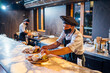 © Westend61 - Chef wearing protective face mask preparing burgers in restaurant kitchen