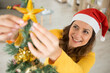 © auremar - cheerful woman holding a golden stars for christmas decoration