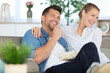 © auremar - cheerful happy couple in love on a couch at home