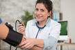 © auremar - happy female doctor is measuring the blood pressure