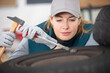 © auremar - young mechanic woman working on wheel in car service