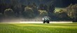 © Khawla - Modern Tractor Spraying Green Agricultural Fields. Tractor spraying crops in a vast green field during daylight hours in a rural agricultural setting