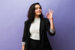 © AntonioDiaz - Professional woman making an ok hand gesture, showing approval and success on an isolated purple studio background
