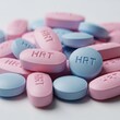 © Olga Ко - Pile of pink and blue oval pills imprinted with 'HRT'. Concept of Hormone Replacement Therapy, menopause treatment, and transgender healthcare.
