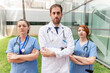 © StockMe - Healthcare team standing outdoors at a hospital, looking determined and serious, healthcare workers ready to assist patients