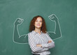 © Igor Link - Smiling businesswoman shows strength, looking into the camera against a free background