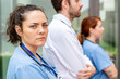 © StockMe - Dedicated healthcare professionals standing together at a hospital, demonstrating seriousness and medical teamwork