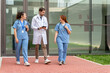© StockMe - Medical team walking and discussing outside hospital building, healthcare professionals collaborating on treatment plans