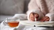 © Mary - Woman writing in notebook while enjoying tea on cozy blanket