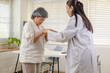 © Rakchanok - Clinic rehabilitation private care, physician encourages senior patient walking with walker, safe movement instruction, balance training, fall prevention screening, progress review appointment.