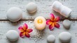 © newofficial - A serene spa setup with candles, flowers, and stones on a wooden surface