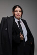 © LIGHTFIELD STUDIOS - Stylish plus size woman exudes confidence in chic formal attire against a neutral backdrop