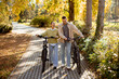 © BGStock72 - Joyful couple enjoying a stroll in a colorful autumn park with bicycles under golden leaves