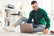 © Prostock-studio - Man Taking Notes Using Laptop Computer Learning Or Working Online Sitting On Floor At Home, Wearing Eyeglasses. E-Learning And Business Accounting Concept. Selective Focus