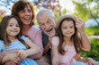© Halfpoint - Grandparents spending time with granddaughters in park.