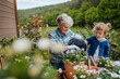 © Halfpoint - Senior grandmother with small granddaughter gardening during spring season.
