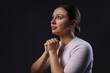 © New Africa - Woman praying on black background, space for text