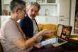 © Geber86 - Senior couple discussing bills on video call at home
